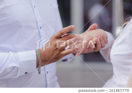 Wedding gold rings on the hands of the newlyweds. Gold rings on the hand of a man and a woman 101865779