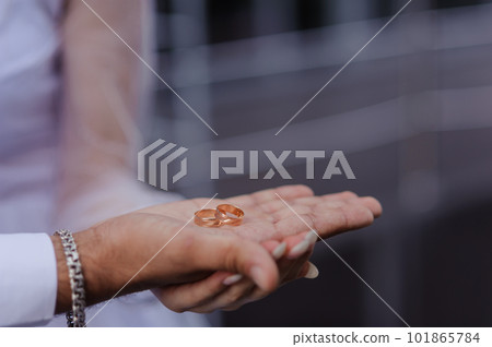 Wedding gold rings on the hands of the newlyweds. Gold rings on the hand of a man and a woman Wedding gold rings on the hands of the newlyweds. Gold rings on the hand of a man and a woman 101865784