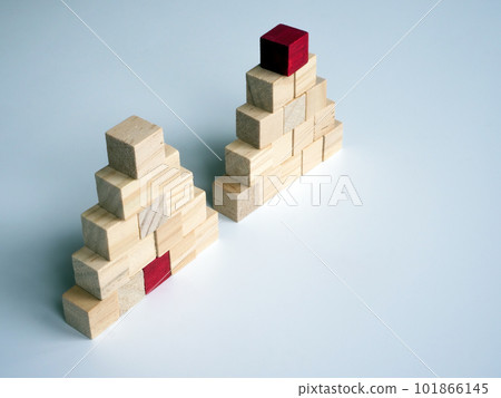 Two pyramids of cubes side by side. Difference between leader and manager concept. 101866145