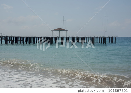 Rocky coast with wooden pier on the sunny day Rocky coast with wooden pier on the sunny day 101867801