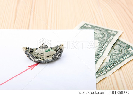 A figurative image of a financial chart and a model of a paper boat folded from a banknote as a symbol of the market. A figurative image of a financial chart and a model of a paper boat folded from a banknote as a symbol of the market. 101868272