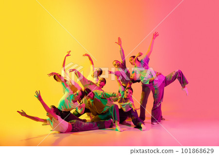 Group of young people, girls dancing contemp against pink and yellow gradient background in neon light. Diversity, chaos and freedom. Group of young people, girls dancing contemp against pink and yellow gradient background in neon light. Diversity, chaos and freedom. 101868629