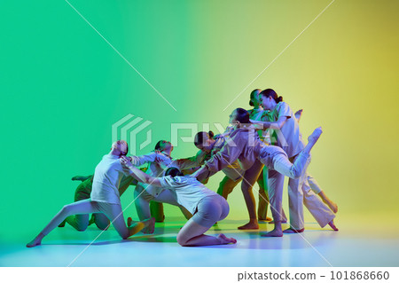 Group of teenagers, young dancers emotionally dancing together on gradient background in neon light. Modern dance style 101868660