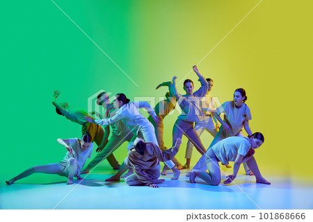 Group of young people dancing contemp against green and yellow gradient background in neon light. Diversity, chaos and freedom Group of young people dancing contemp against green and yellow gradient background in neon light. Diversity, chaos and freedom 101868666