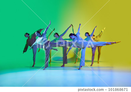 Dance team of young adorable girls moving to the beat of the music on gradient background in neon light. Improvisation performance 101868671