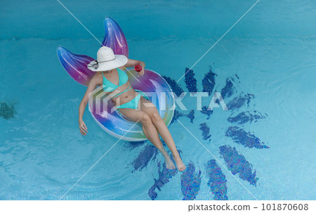 Woman in bikini with rubber inflatable float. Woman in swimsuit on the swim tube in swimming pool. Woman in bikini with rubber inflatable float. Woman in swimsuit on the swim tube in swimming pool. 101870608