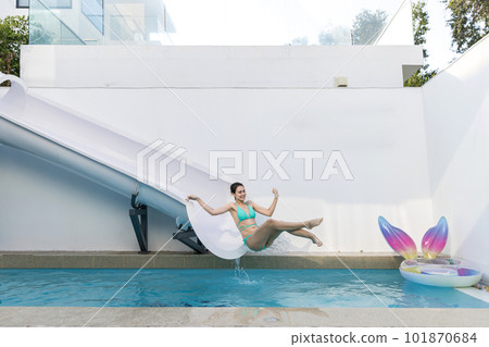 Woman in swimsuit playing slider at poo villa. Woman in bikini playing slider. Woman in swimsuit playing slider at poo villa. Woman in bikini playing slider. 101870684