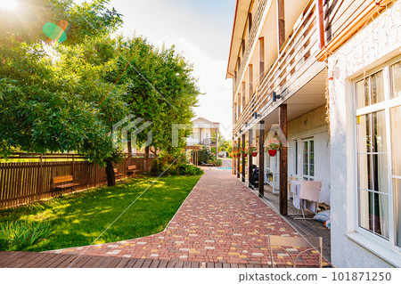 A tiled path near the two-story residential building of the guest house. A tiled path near the two-story residential building of the guest house. 101871250