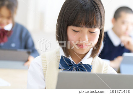 Female junior high school student in class staring at the PC screen Female junior high school student in class staring at the PC screen 101871458