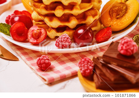 waffles, powder with strawberries, apricots, cherries, juice and a cup of black coffee 101871866