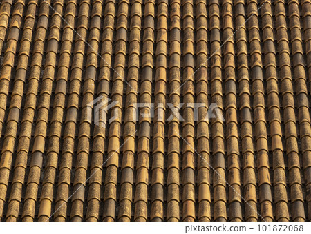 Old tile roof above the house and hard shadows from sunny in a summer day. Aerial top view from drone. Beautiful background. Old tile roof above the house and hard shadows from sunny in a summer day. Aerial top view from drone. Beautiful background. 101872068
