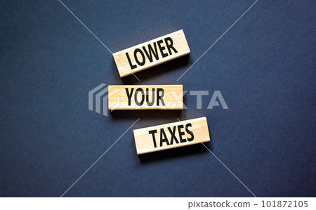 Lower your taxes symbol. Concept words Lower your taxes on wooden blocks on a beautiful black table black background. Business tax lower your taxes concept. Copy space. Lower your taxes symbol. Concept words Lower your taxes on wooden blocks on a beautiful black table black background. Business tax lower your taxes concept. Copy space. 101872105
