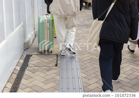 Women's feet pulling a carry case 101872336