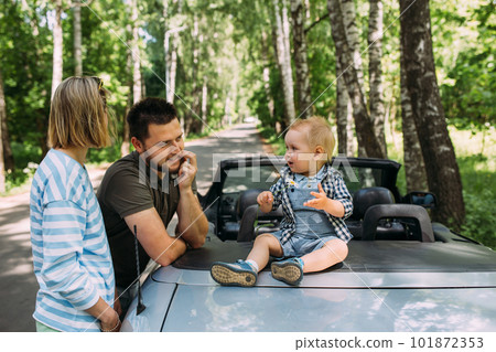 Mom, dad and little son in a convertible car. Summer family road trip to nature Mom, dad and little son in a convertible car. Summer family road trip to nature 101872353