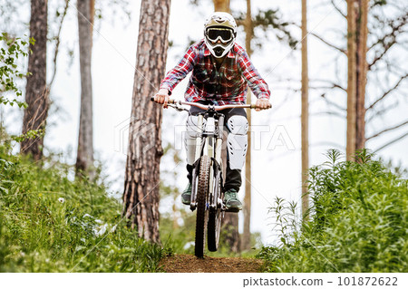 front view racer athlete riding downhill race in mountain bike, on him protection knee and shin guard 101872622