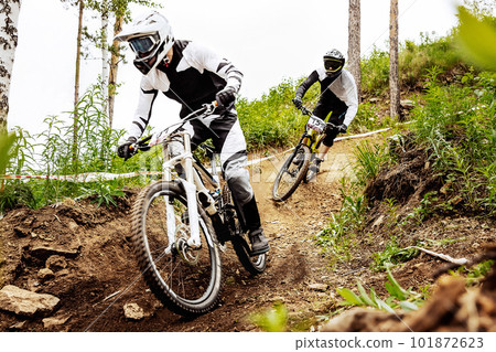 two racer athlete riding downhill training race in mountain bike, sports summer games two racer athlete riding downhill training race in mountain bike, sports summer games 101872623