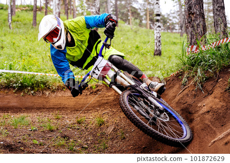 male racer athlete riding cornering turn downhill race, sports summer games in mountain bike 101872629