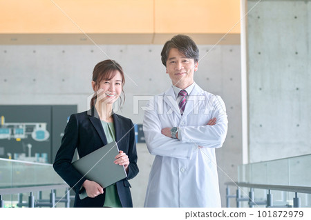 A doctor in a white coat and an MR woman in a suit meeting at a hospital A doctor in a white coat and an MR woman in a suit meeting at a hospital 101872979