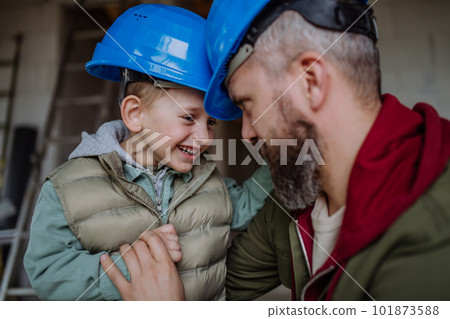 Father and his little son cuddling in their unfinished house. Father and his little son cuddling in their unfinished house. 101873588