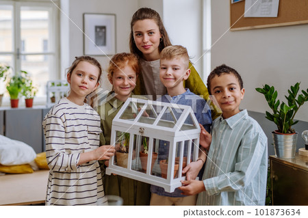 Young teacher learning pupils how to take care about plants. 101873634
