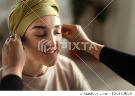 Somebody giving sfarf on head to young woman with cancer, concept of support. 101873699