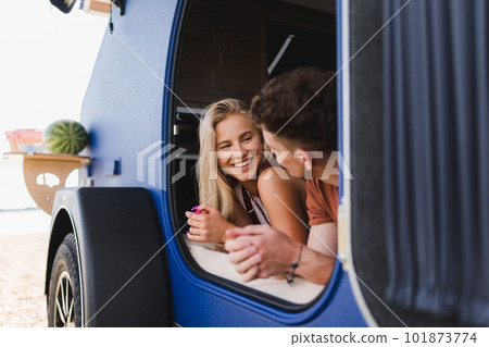 Happy young couple lying together in a van, enjoying vacation time together. 101873774