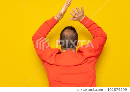 Half-bald man energetically clapping his back, he is excited about the spectacle he has just witnessed. Isolated on yellow background Half-bald man energetically clapping his back, he is excited about the spectacle he has just witnessed. Isolated on yellow background 101874209