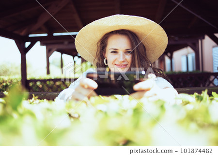 smiling woman in shirt sending text message using smartphone smiling woman in shirt sending text message using smartphone 101874482