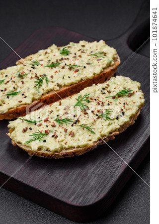 Grilled toast with avocado paste, eggs, cream cheese, salt, spices and herbs 101874641