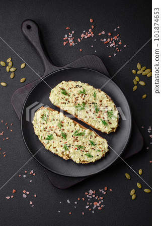Grilled toast with avocado paste, eggs, cream cheese, salt, spices and herbs 101874653