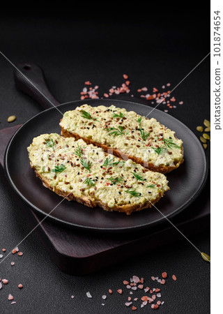 Grilled toast with avocado paste, eggs, cream cheese, salt, spices and herbs 101874654