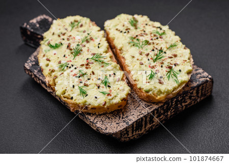 Grilled toast with avocado paste, eggs, cream cheese, salt, spices and herbs 101874667