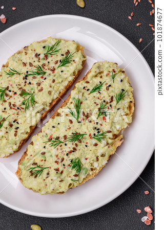 Grilled toast with avocado paste, eggs, cream cheese, salt, spices and herbs 101874677