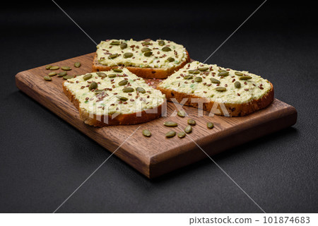 Grilled toast with avocado paste, eggs, cream cheese, salt, spices and herbs 101874683