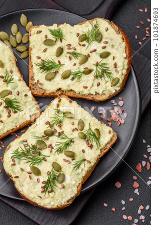 Grilled toast with avocado paste, eggs, cream cheese, salt, spices and herbs 101874693