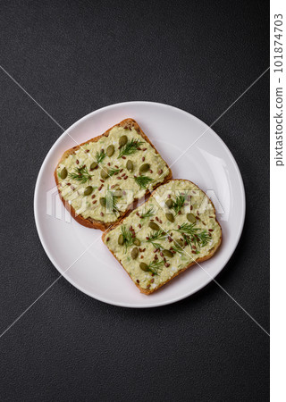 Grilled toast with avocado paste, eggs, cream cheese, salt, spices and herbs 101874703