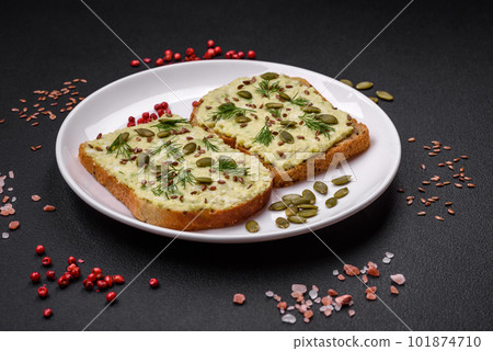 Grilled toast with avocado paste, eggs, cream cheese, salt, spices and herbs 101874710