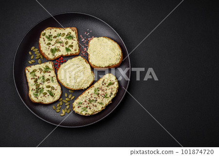 Grilled toast with avocado paste, eggs, cream cheese, salt, spices and herbs 101874720