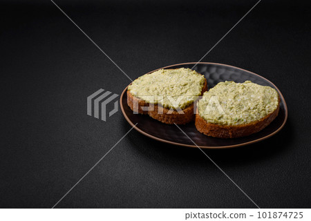 Grilled toast with avocado paste, eggs, cream cheese, salt, spices and herbs 101874725
