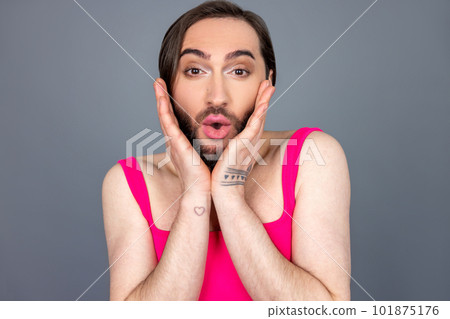 Surprised transsexual wearing pink top sees something astonished keeps palms on cheeks saying wow Surprised transsexual wearing pink top sees something astonished keeps palms on cheeks saying wow 101875176