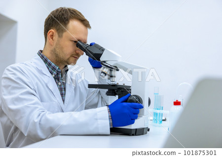 Scientist man doing chemical experiment, making analyzing, looking sample under microscope Scientist man doing chemical experiment, making analyzing, looking sample under microscope 101875301