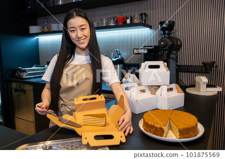 Joyful pastry shop worker packing takeaway flour confectionery 101875569