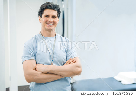 Dark-haired male physical therapist looking confident and smiling 101875580