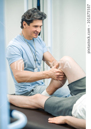 Confident doctor working with the patient in rehabilitation center Confident doctor working with the patient in rehabilitation center 101875587