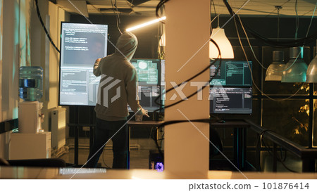 Dangerous spy gaining unauthorized access into computer system, doing phishing for security breach. Person using encryption to convert data and commit cyberbullying. Handheld shot. 101876414