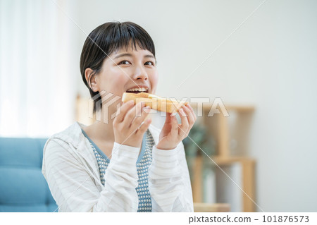 A woman eating breakfast A young woman eating 101876573