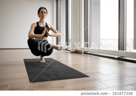 Woman balancing on one leg and keeping hands in namaste 101877288
