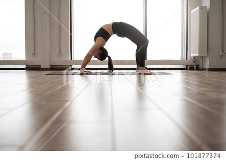 Attractive yogi standing in Urdhva Dhanurasana pose 101877374