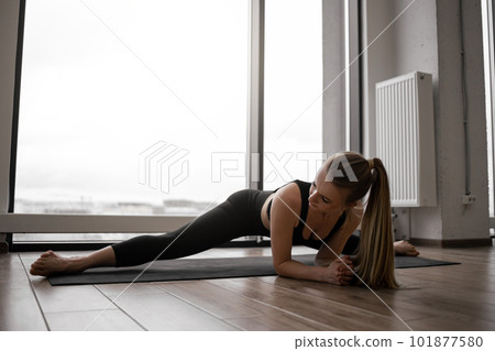 Female doing Upavistha Konasana during workout in studio Female doing Upavistha Konasana during workout in studio 101877580