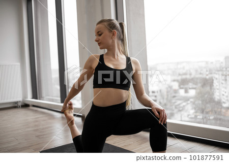 Yogini taking up Low Crescent Lunge Pose in yoga studio Yogini taking up Low Crescent Lunge Pose in yoga studio 101877591
